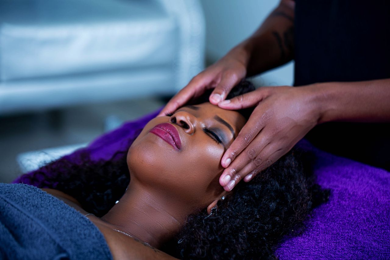 Woman receiving a calming head massage at a spa, capturing relaxation and tranquility.